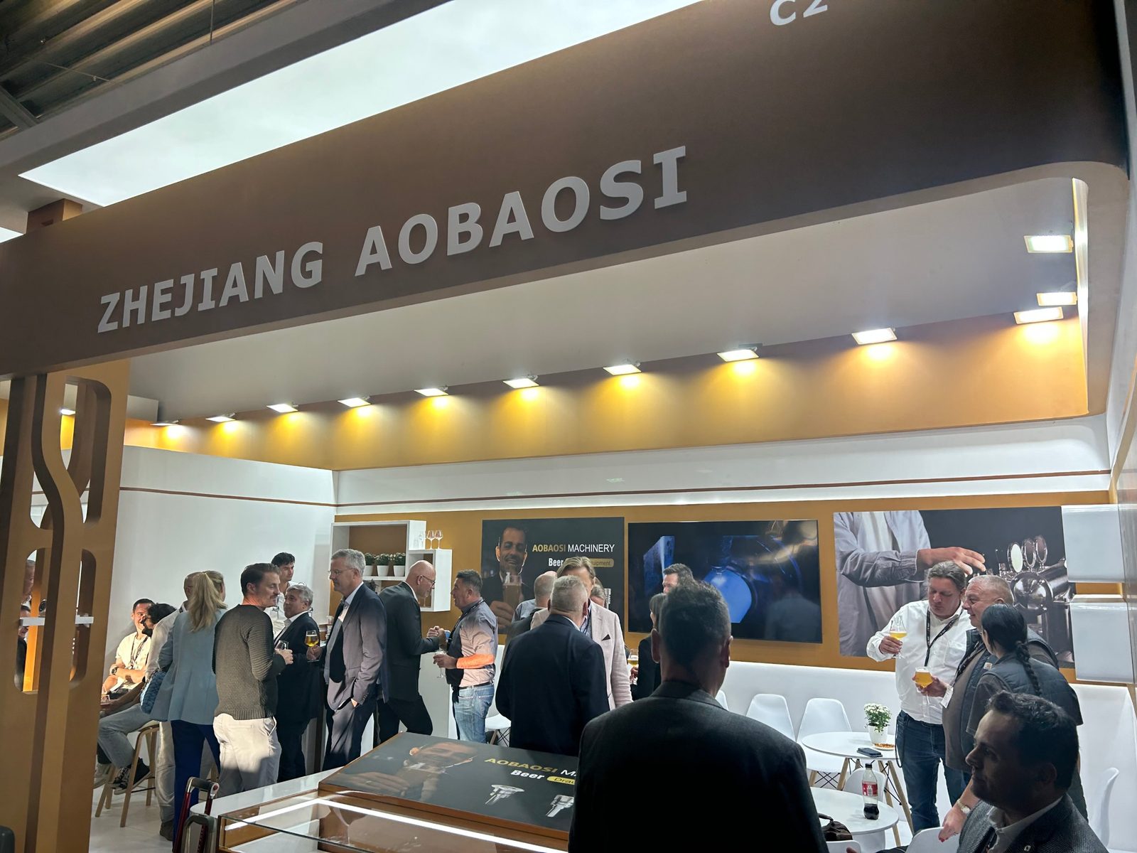 Visitors talking at the Zhejiang Aobaosi stand at drinktec 2025